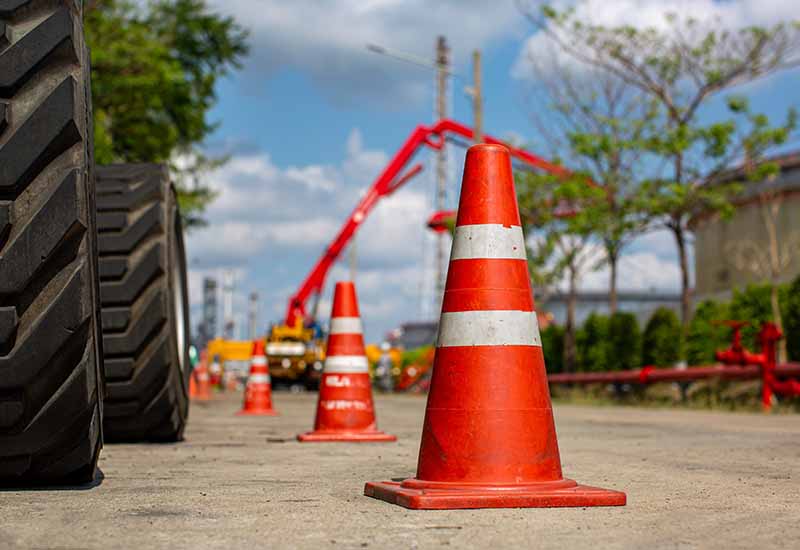 Construction cones placed on the road to indicate a heavy equipment hazard in a construction zone.