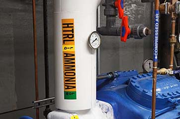 A clearly labeled pipe that is transporting ammonia. 