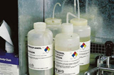 Four GHS wash bottles are labeled appropriately to meet safety standards.