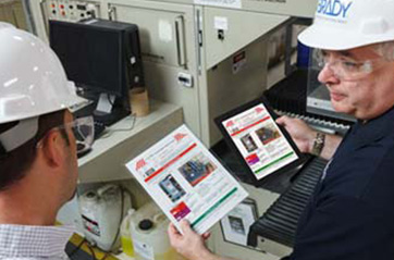 Two workers discuss protocol for auditing a lockout tagout program.