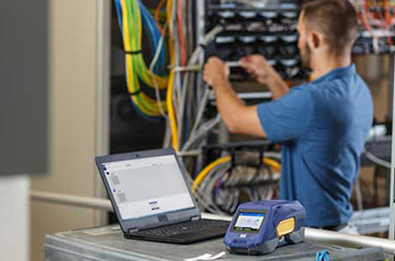 A worker organizing the cables on a large industrial machine.