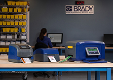 Three Brady benchtop printers on an industrial workbench.