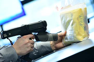 A person scanning a product with a handheld RFID reader.