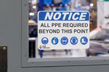A sign on a door window that says "NOTICE ALL PPE REQUIRED BEYOND THIS POINT."