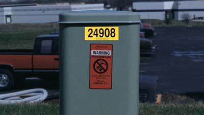 A reflective label on an outdoor electrical component.