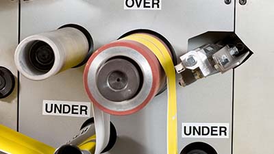 Labels show the direction of a roll-to-roll machine's output.