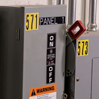 Electrical panels with multiple labels for warning and identification.