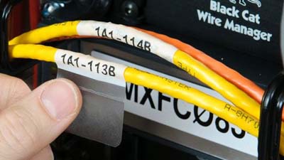 Aggressive adhesive labels wrapped around wires.